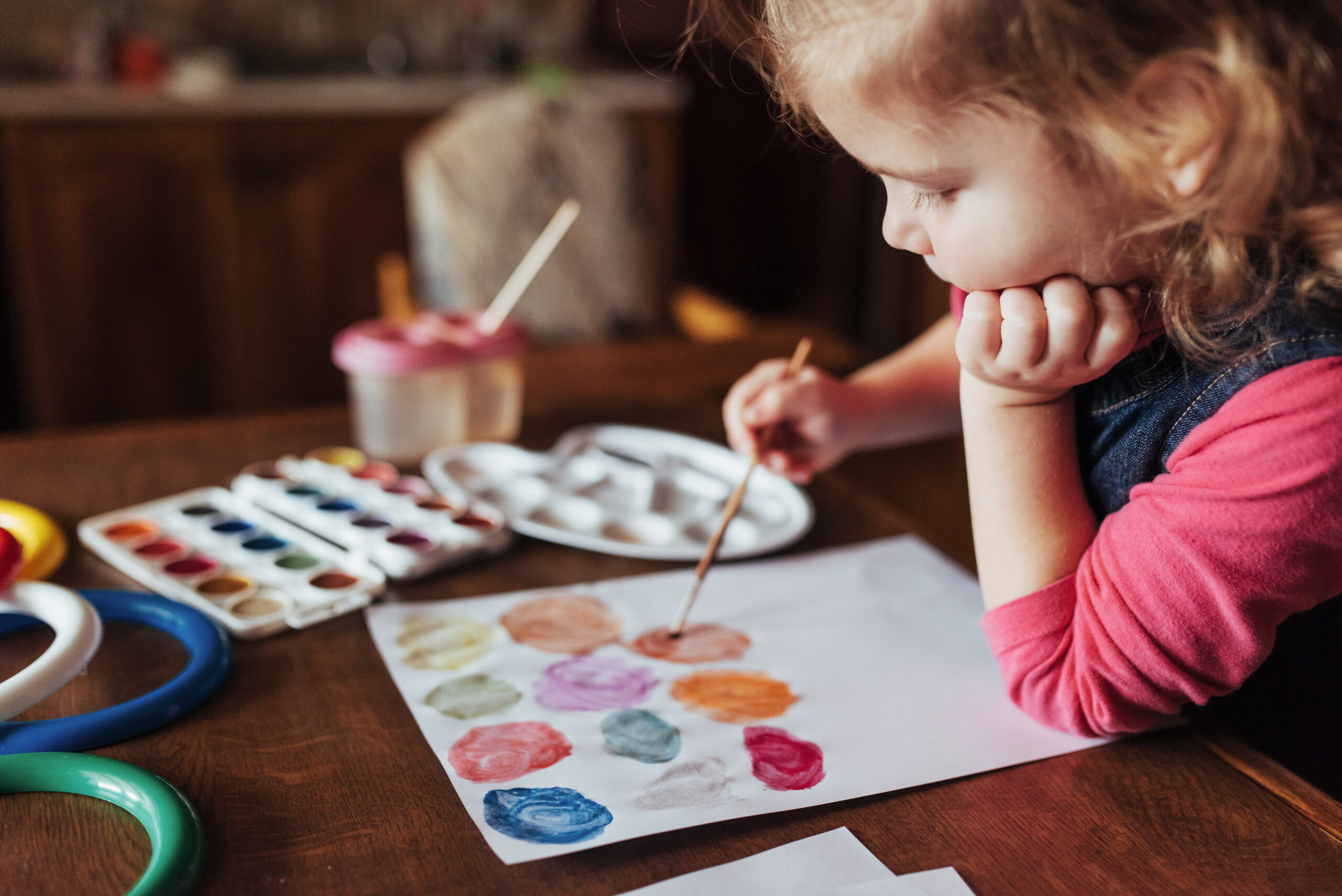 Cute happy little girl, adorable preschooler, painting with water color on canvas. Baby close up.