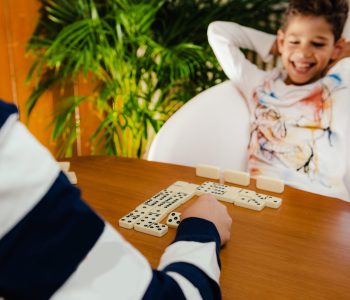 Boy playing dominoes at home.