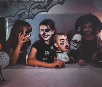 Happy kids in creepy Halloween costumes and makeup enjoying their little party.