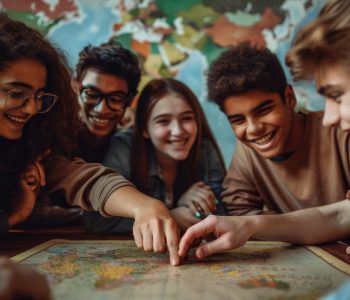 Diverse Group of Smiling Teens Studying a World Map Together, Connecting with peers from around the world for cultural exchange and project collaboration